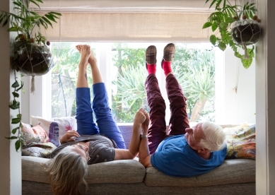 Senior Couple Sitting on Couch with Feet in Air